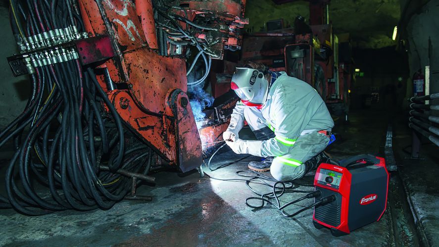 man performing maintenance on heavy duty machinery with battery powered welder