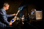 man programming a robotic plasma cutter connected to 105HD power source