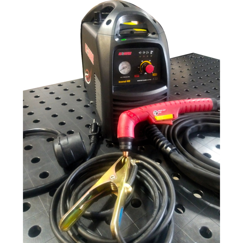crossfire invercut 40 amp portable plasma cutter on top of welding table showing cutting torch, ground clamp, and 110 volt adapter