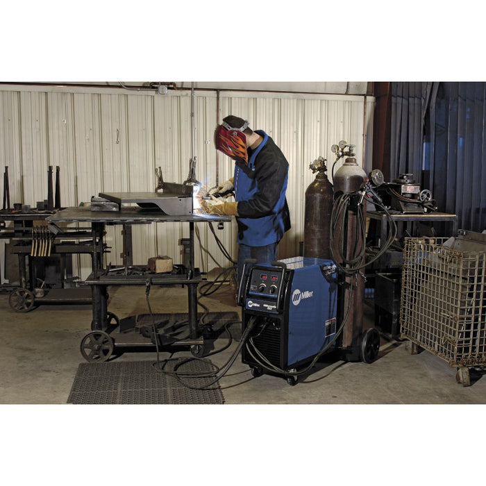 a man in a shop welding with his miller millermatic 252 mig welder