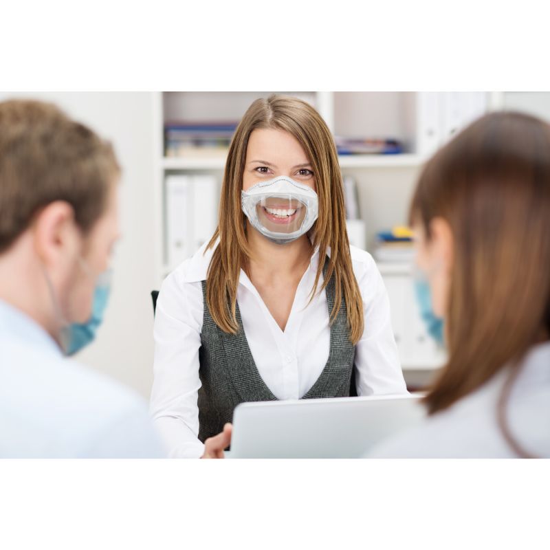 three people together wearing clear n95 masks smiling